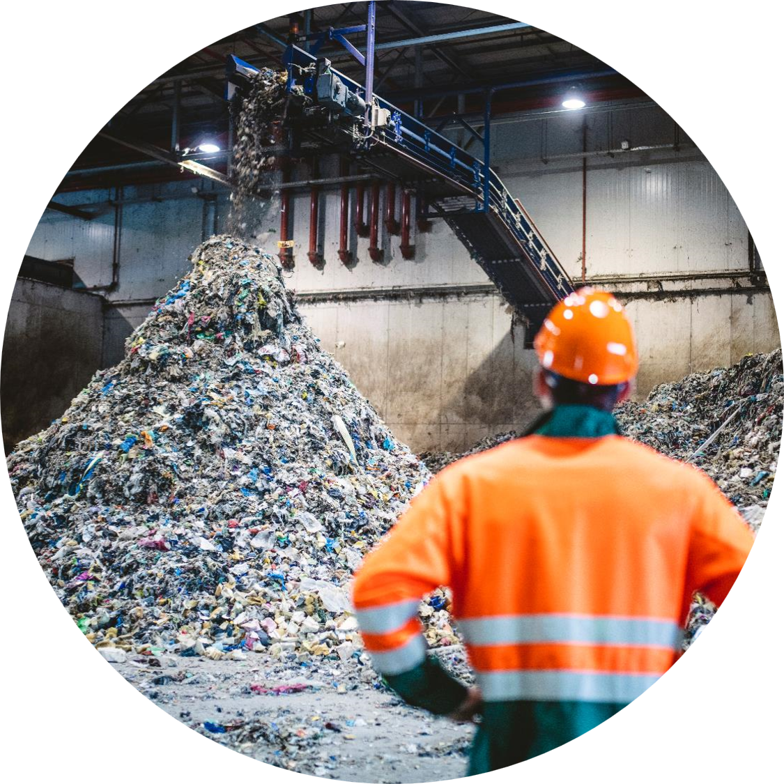 リサイクルセンターでゴミの山を見つめている男