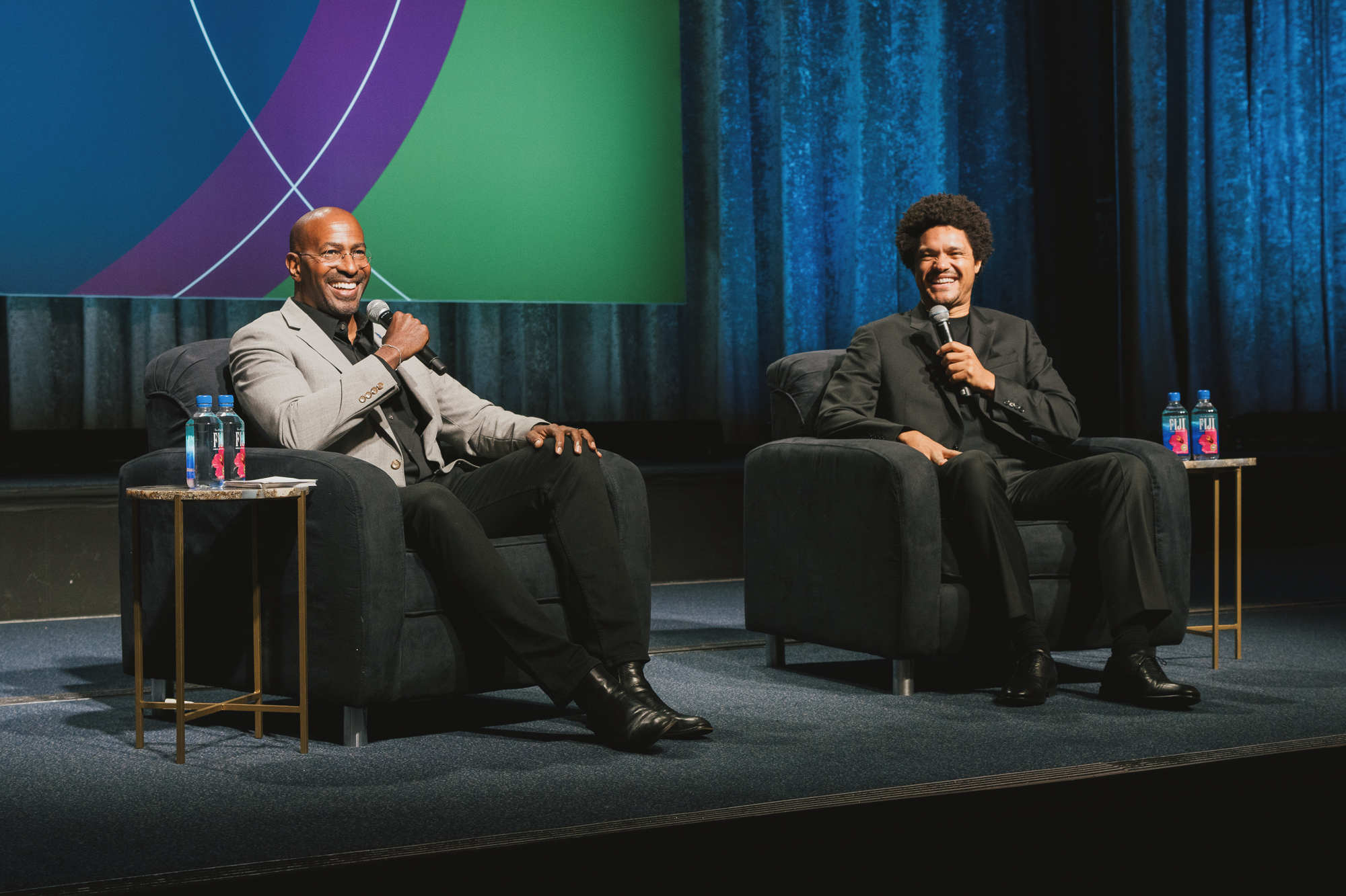 SEMコンソーシアム2025で笑顔のステージ上のトレバーノアとヴァンジョーンズ